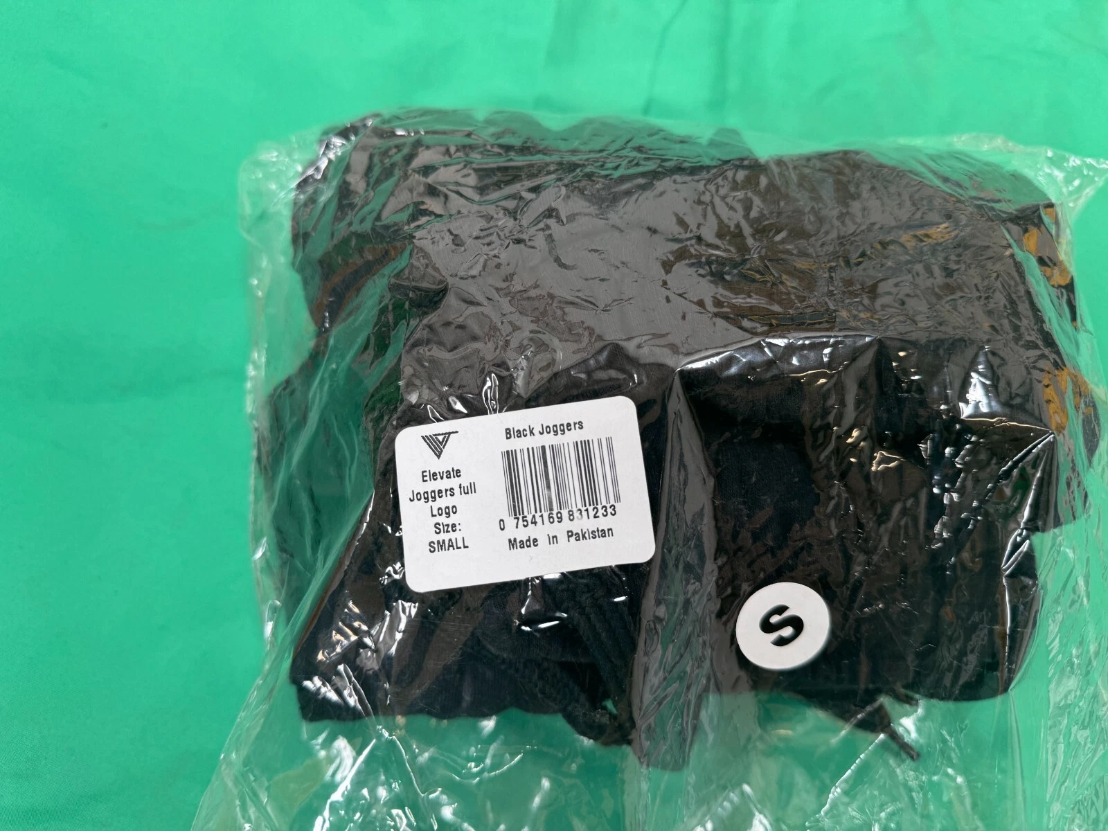 Packaged Elevate black joggers with size small label and barcode visible